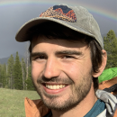 Young man with rainbow in background. 